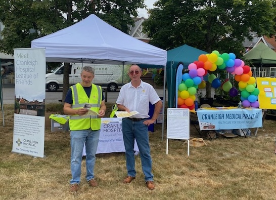Two men standing in front of a gazebo at a carnival.