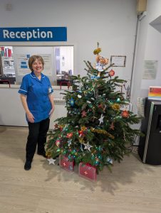Nurse standing next to a Christmas tree
